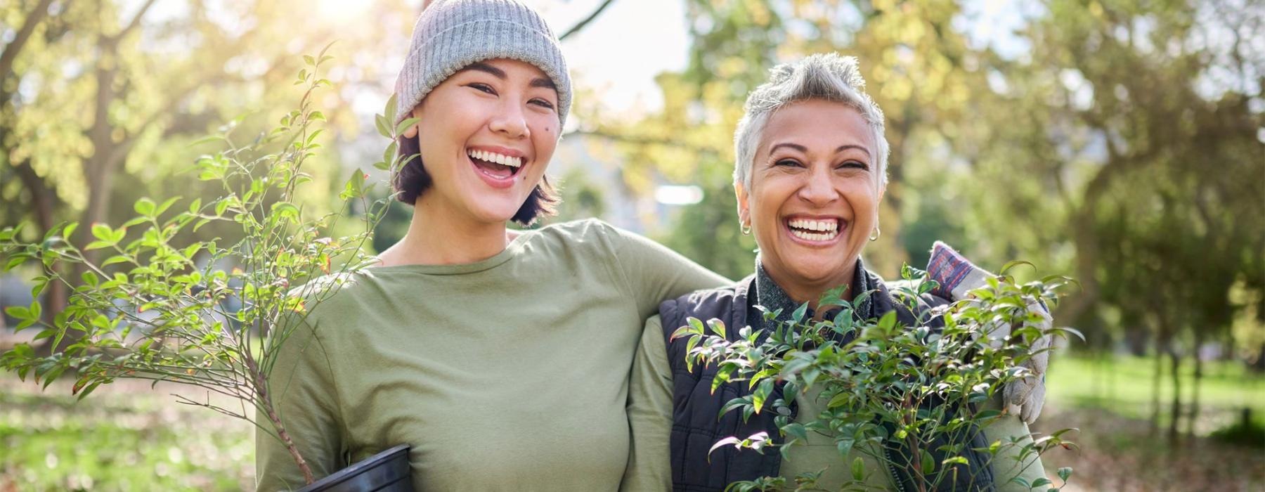 a couple of women holding plants